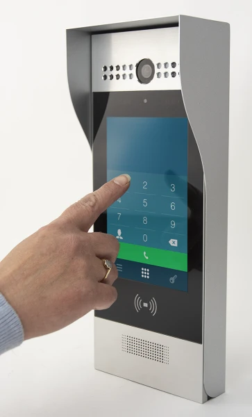 hand pressing on touch screen of an intercom system